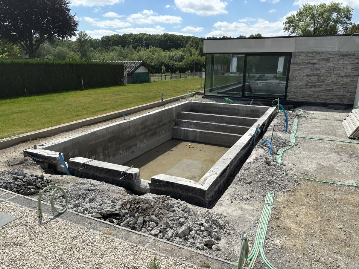 Bassin en blocs en cours de construction devant un pool house