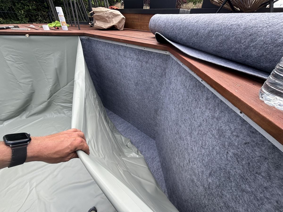Lucas en train de poser un nouveau liner sur une piscine en bois