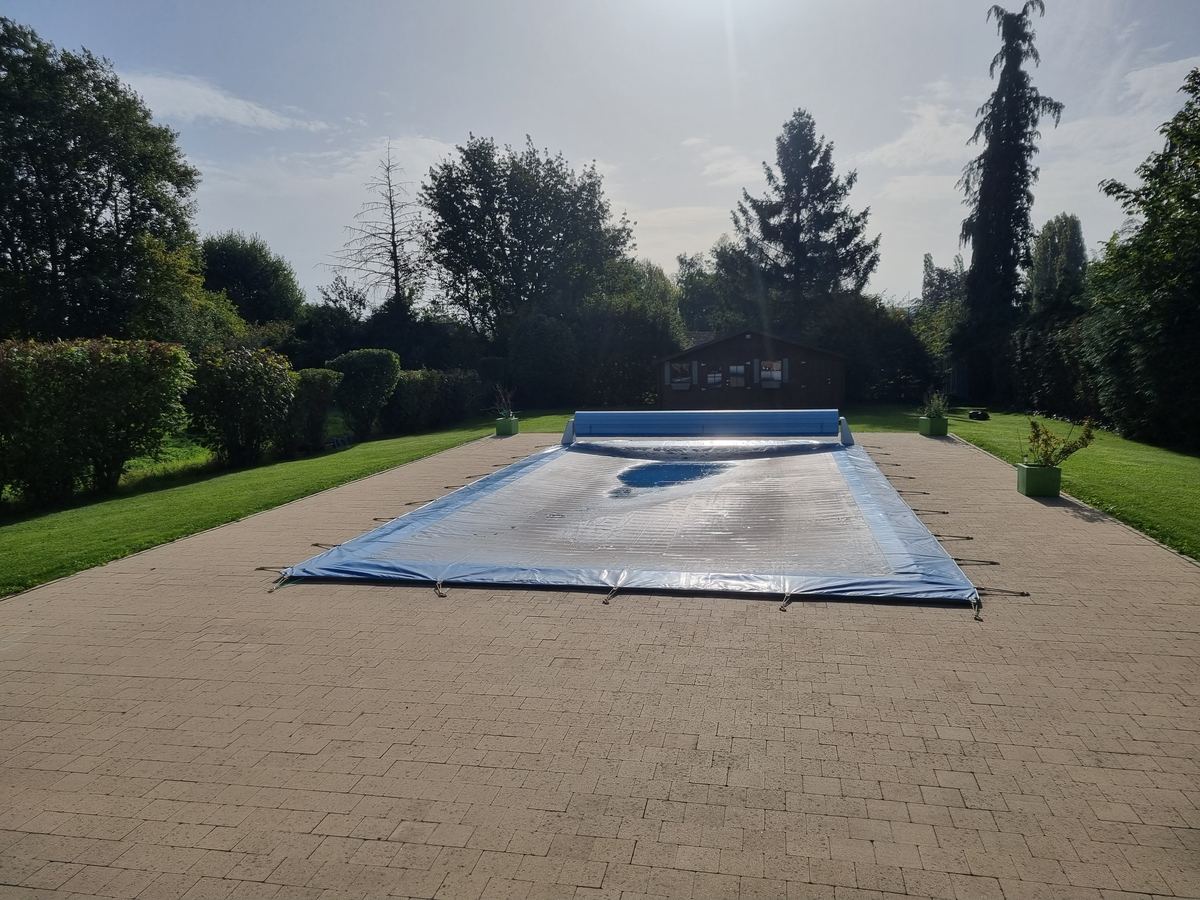 Piscine hivernée sous sa bâche d'hivernage, dans un grand jardin