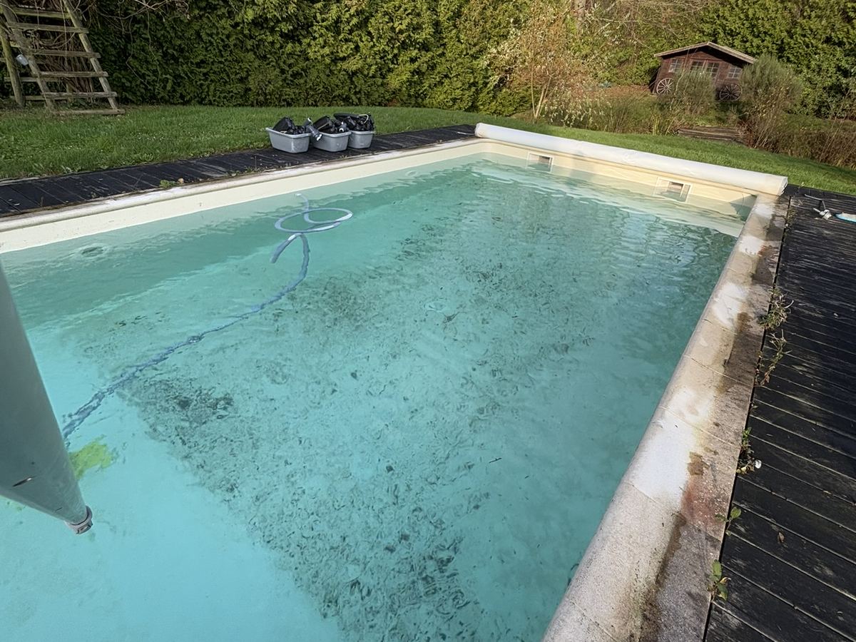 Piscine à la sortie de l'hiver : eau trouble et dépôts au fond avant la remise en route
